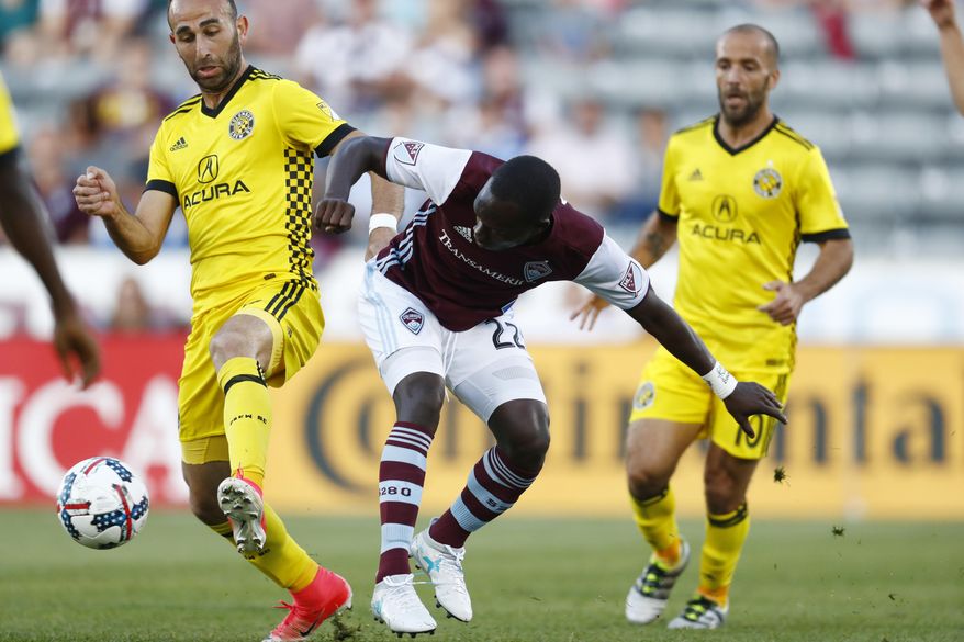 Columbus Crew forward Justin Meram, left, fights for control of the ball with Colorado Rapids midfielder Michael Azira, center, as Crew forward Federico Higuain covers in the first half of an MLS soccer game Saturday, June 3, 2017, in Commerce City, Colo. (AP Photo/David Zalubowski)