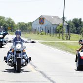 U.S. Sen. Joni Ernst, R-Iowa, center, waves to a rider as she leads a group of motorcyclists to her annual fundraiser, Saturday, June 3, 2017, in Boone, Iowa. (AP Photo/Charlie Neibergall)