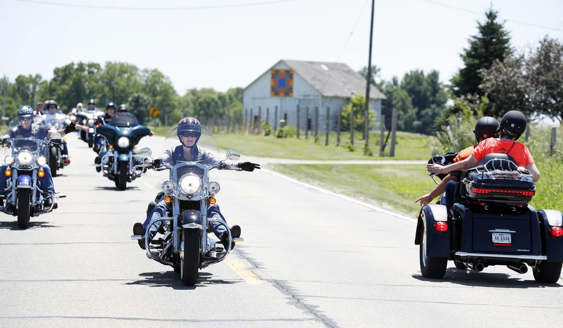 U.S. Sen. Joni Ernst, R-Iowa, center, waves to a rider as she leads a group of motorcyclists to her annual fundraiser, Saturday, June 3, 2017, in Boone, Iowa. (AP Photo/Charlie Neibergall)