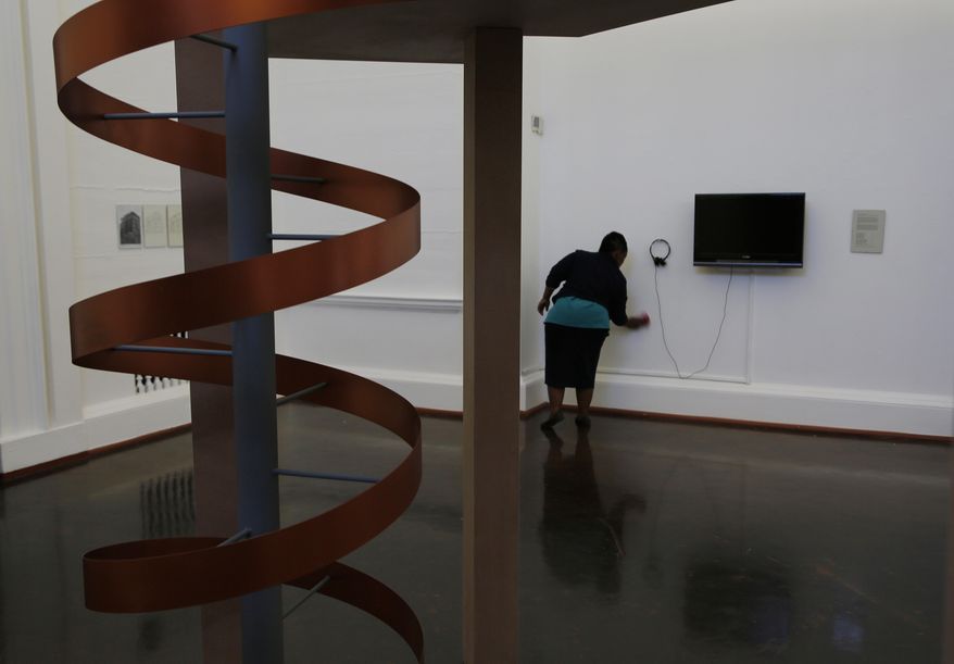 In this photo taken Friday, May 19, 2017, a worker cleans inside the Johannesburg Art Gallery, in Joubert Park, Johannesburg. In the latest chapter of its troubled history, the gallery re-opened on May 7 after a three-month closure that allowed workers to shift art from an area vulnerable to rain leaks because of the theft of roof material into safer storage spaces. (AP Photo/Denis Farrell)