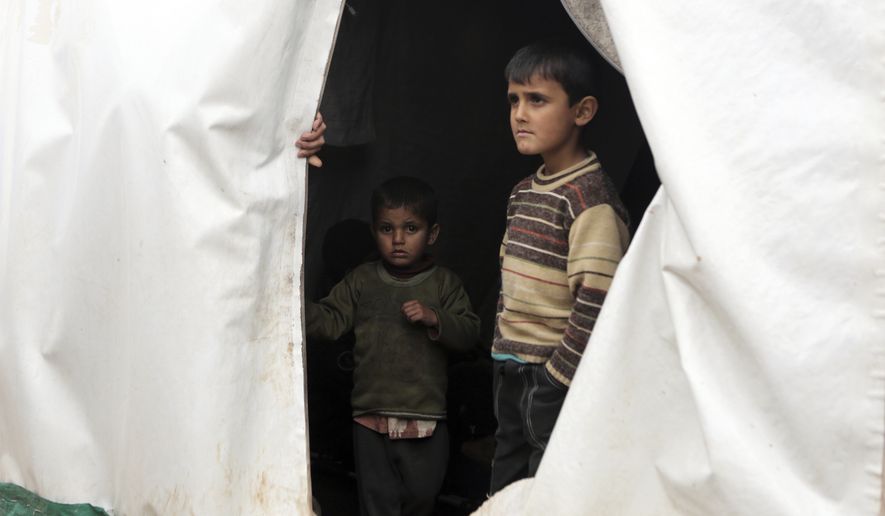Syrian children, evacuated from Aleppo, stand inside a tent at a refugee camp near Idlib, Syria, Friday, Dec. 16, 2016. Turkey&#39;s Foreign Minister Mevlut Cavusoglu says 7,500 civilians have been evacuated from the Syrian city of Aleppo and that he has reached out to Tehran in a bid to keep the process on track.(AP Photo)