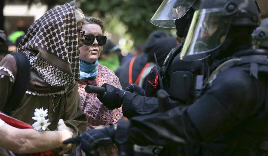 Police officers move to clear demonstrators from Chapman Square near City Hall in downtown Portland, Oreg., Sunday, June 4, 2017, declaring it an unlawful assembly, as they gathered following last month&#39;s fatal stabbing of two men who tried to stop another man&#39;s anti-Muslim tirade. A pro-Donald Trump free speech rally organized by a conservative group drew hundreds near City Hall. The group was met by hundreds of counter-protesters organized by immigrant rights, religious and labor groups. (Dave Killen/The Oregonian via AP)