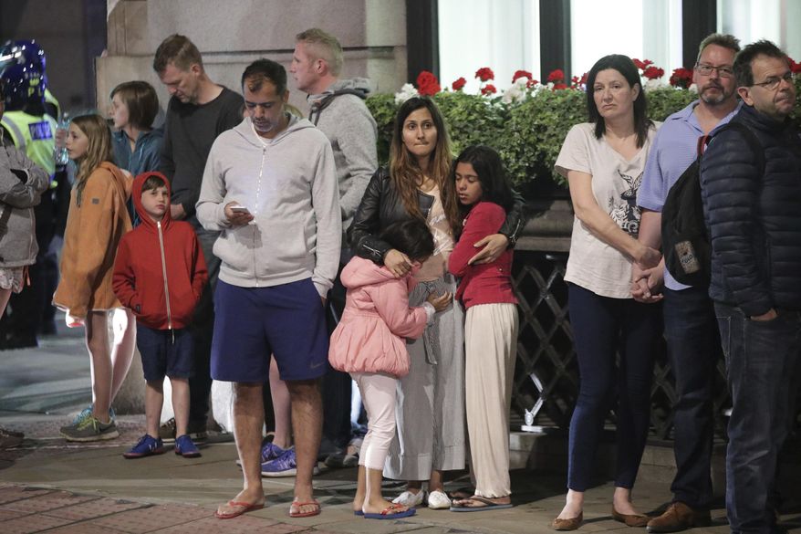 Guests from the Premier Inn Bankside Hotel are evacuated and kept in a group with police on Upper Thames Street following an attack in central London, Saturday, June 3, 2017. Terrorism struck at the heart of London, police said Sunday, after a vehicle veered off the road and mowed down pedestrians on London Bridge and gunshots rang out amid reports of knife attacks at nearby Borough Market. (Yui Mok/PA via AP)