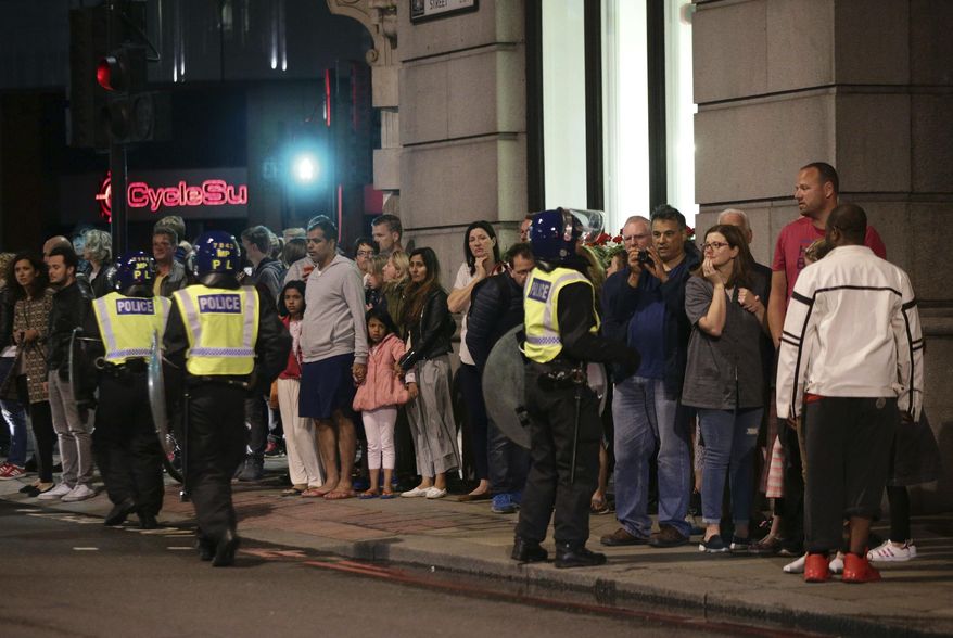 Guests from the Premier Inn Bankside Hotel are evacuated and kept in a group with police on Upper Thames Street following an attack in central London, Saturday, June 3, 2017. Terrorism struck at the heart of London, police said Sunday, after a vehicle veered off the road and mowed down pedestrians on London Bridge and gunshots rang out amid reports of knife attacks at nearby Borough Market. (Yui Mok/PA via AP)