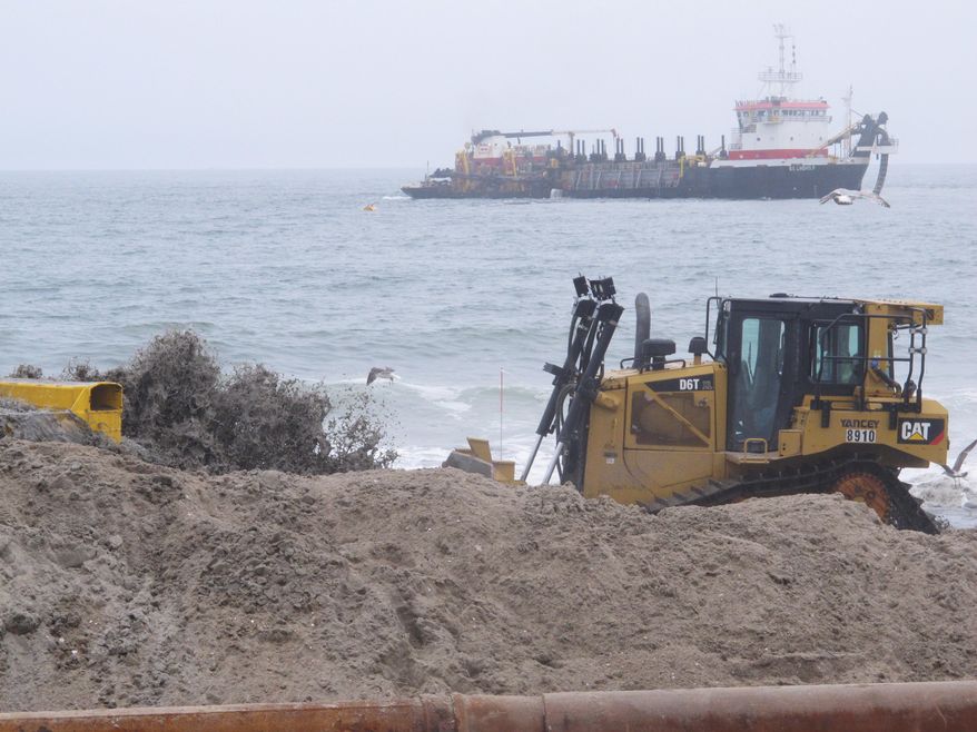 In this May 31, 2017 photo, sand pumped from an offshore ship flows from a pipe on the beach as a bulldozer moves the sand around in the Ortley Beach section of Toms River, N.J., one of the hardest-hit spots by Superstorm Sandy. Nearly five years after the storm, New Jersey is closing in on its goal of having protective dunes along its coast, but pockets of resistance remain among residents fighting the dune plan in court. (AP Photo/Wayne Parry)
