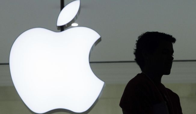 In this Wednesday, Dec. 7, 2011, file photo, a person stands near the Apple logo at the company&#x27;s store in Grand Central Terminal, in New York. (AP Photo/Mark Lennihan, File)