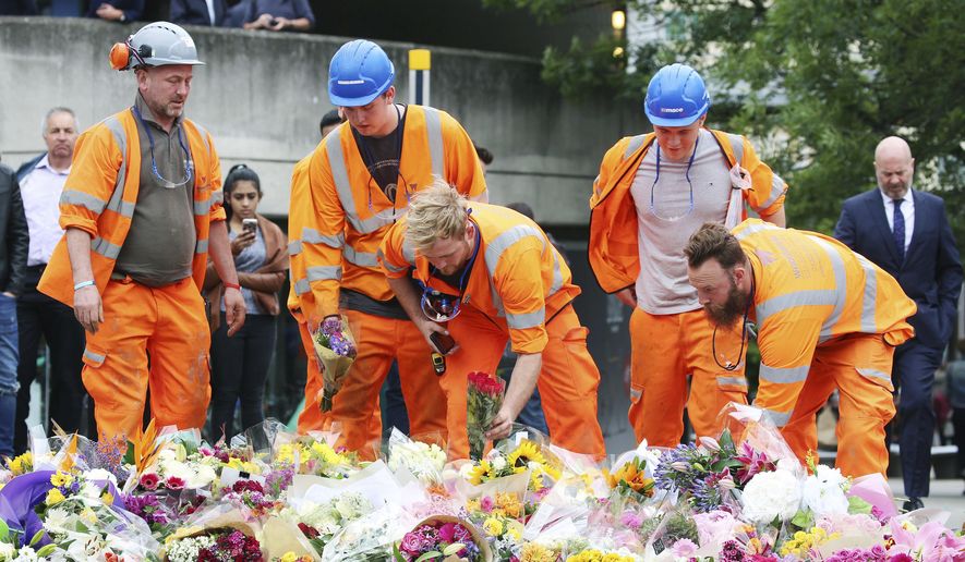 Construction workers leave flowers near the attack scene at London Bridge following Saturday&#x27;s attack Monday June 5, 2017. (Isabel Infantes/PA via AP)