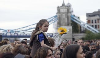 People attend a vigil for victims of Saturday&#39;s attack in London Bridge, at Potter&#39;s Field Park in London, Monday, June 5, 2017. Police arrested several people and are widening their investigation after a series of attacks described as terrorism killed several people and injured more than 40 others in the heart of London on Saturday. (AP Photo/Tim Ireland)