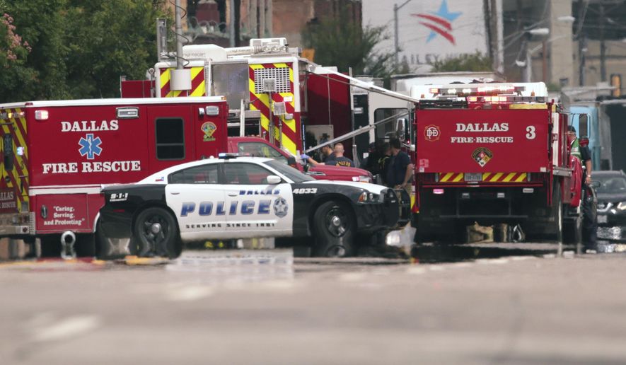 Emergency response crews gather on a closed street in front of the Dallas police headquarters in Dallas, Monday, June 5, 2017. A portion of the Dallas police headquarters has been evacuated and nearby streets closed after a suspicious package was found. (AP Photo/LM Otero)