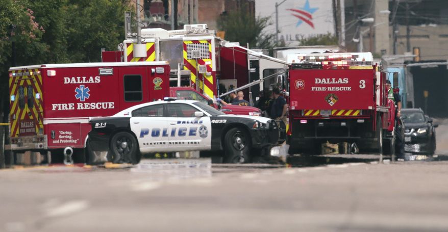 Emergency response crews gather on a closed street in front of the Dallas police headquarters in Dallas, Monday, June 5, 2017. A portion of the Dallas police headquarters has been evacuated and nearby streets closed after a suspicious package was found. (AP Photo/LM Otero)