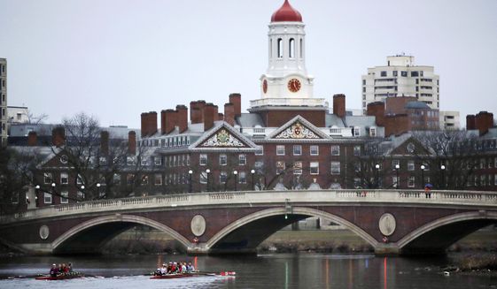 Rowers paddle along the Charles River past the Harvard College campus in Cambridge, Mass. (AP Photo/Charles Krupa, File)