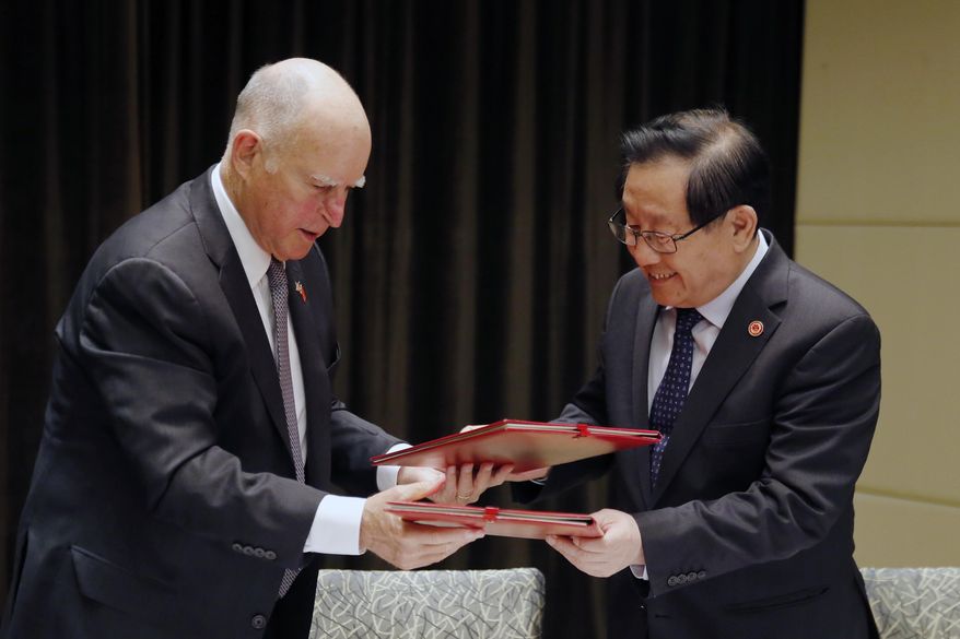 California Gov. Jerry Brown, left, exchanges memorandum of understanding with China's Science and Technology Minister Wan Gang after the Clean Technology signing ceremony at a hotel in Beijing, Tuesday, June 6, 2017. (AP Photo/Andy Wong)