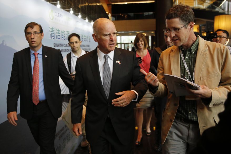California Gov. Jerry Brown, center, talks with reporters after delivering a speech during the Clean Energy Ministerial International Forum on Electric Vehicle Pilot Cities and Industrial Development, at a hotel in Beijing, Tuesday, June 6, 2017. Brown predicts that President Donald Trump's decision to pull the U.S. out of the Paris climate accord will prove temporary because of the urgency of the issue. He told The Associated Press on the sidelines of a clean energy conference in Beijing on Tuesday that China, Europe and U.S. state governors will for now fill the gap left by the federal government's move to abdicate leadership on the issue. (AP Photo/Andy Wong)