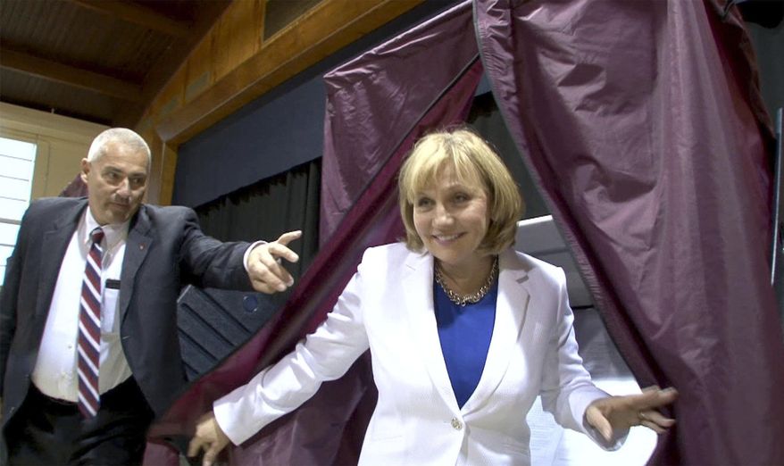 A State Trooper, left, holds the curtain open for Republican gubernatorial candidate and New Jersey Lt. Gov. Kim Guadagno after she voted in the state's primary election at the Church of the Precious Blood Parish Center, Tuesday, June 6, 2017, in Monmouth Beach, N.J. (Thomas P. Costello/The Asbury Park Press via AP)