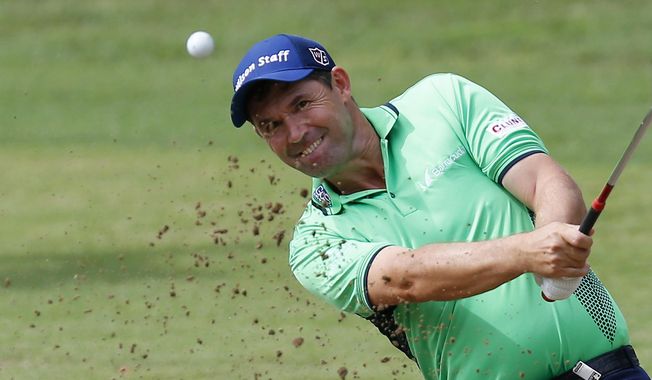 FILE - In this Sept. 16, 2016, file photo, Padraig Harrington hits the ball out of a bunker during the 73th Italy Open Golf Championship in Monza, Italy. Harrington was struck in the elbow doing a clinic and received six stiches, causing him to pull out of the FedEx St. Jude Classic this week. (AP Photo/Antonio Calanni, File)