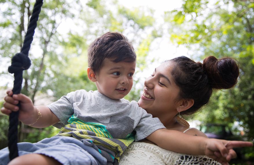 In this May 31, 2017 photo, Susie Gonzalez plays with her son Xavier outside their home in Omaha, Neb. Gonzalez dropped out of high school during her junior year when she gave birth to her son. Under a new state law, Nebraska public schools must outline how they'll address a number of challenges faced by teen parents. (Rebecca Gratz/Omaha World-Herald via AP)