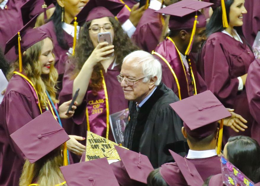 Vermont Sen. Bernie Sanders walks between graduates as he arrives for the Brooklyn College commencement ceremony, Tuesday, May 30, 2017, in New York. The former Democratic presidential candidate, who hails from Brooklyn and attended the school for a year, urged graduates to stand together and not let demagogues divide the country. (AP Photo/Bebeto Matthews)