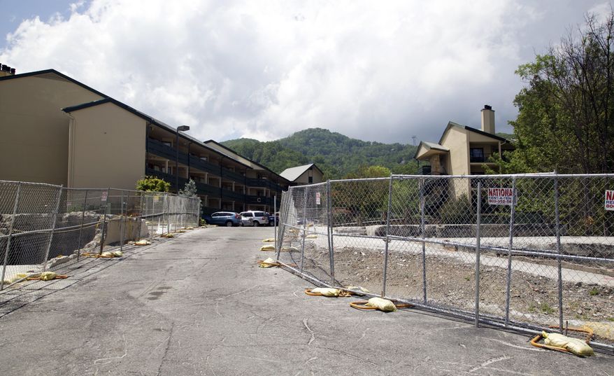 In this May 20, 2017 photo, fencing surrounds areas of the Laurel Point Resort in Gatlinburg, Tenn., that were damaged in a wildfire in 2016. A deadly wildfire in November of 2016 put a dent in the tourism industry, but signs of growth are returning. (AP Photo/Kristin Hall)