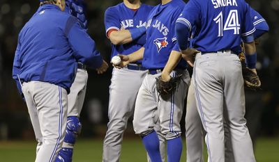 Toronto Blue Jays pitcher Marco Estrada, second from right, hands the ball to manager John Gibbons as he is relieved in the sixth inning of a baseball game against the Oakland Athletics Tuesday, June 6, 2017, in Oakland, Calif. (AP Photo/Ben Margot)