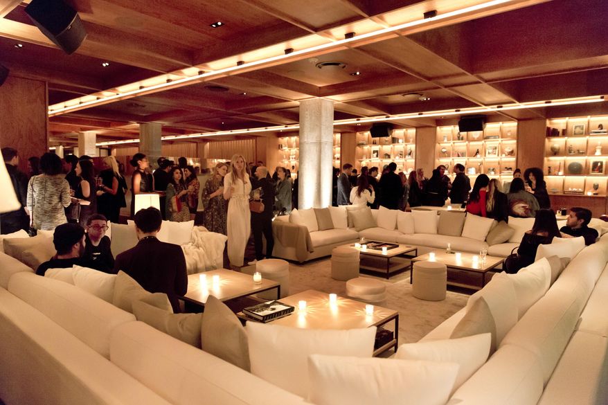 People gather in a plush seating area at the PUBLIC Hotel opening party, in New York, Tuesday June 6, 2017. The PUBLIC hotel has a variety of inviting spaces, from bars to tables to big white sofas, where hotel guests, locals and others can socialize, mingle, relax or work. The edgy decor mixes elements like neon-lit escalators, metal-studded armchairs and faux fur.(AP Photo/Richard Drew)