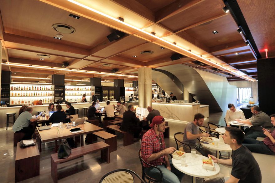 In this June 1, 2017 photo, people dine in the Louis space in the lobby of the PUBLIC hotel, in New York. The area is part grocery, part coffee shop, and part luncheonette. The new hotel on Manhattan's Lower East Side opens Wednesday, June 7. It is the latest project from Ian Schrager, who's known for introducing the concept of boutique hotels and as co-founder of the legendary disco Studio 54. (AP Photo/Richard Drew)