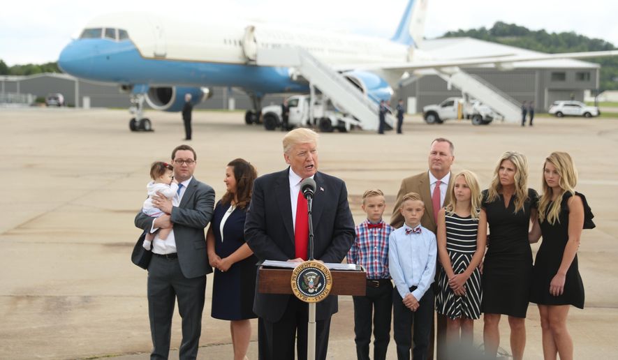 President Donald Trump speaks about health care at Cincinnati Municipal Lunken Airport in Cincinnati, Ohio, Wednesday, June 7, 2017. Shown are PlayCare co-owner Rays Whalen, left, and CSS Distribution Group President Dan Withrow and their families.  (AP Photo/Andrew Harnik)