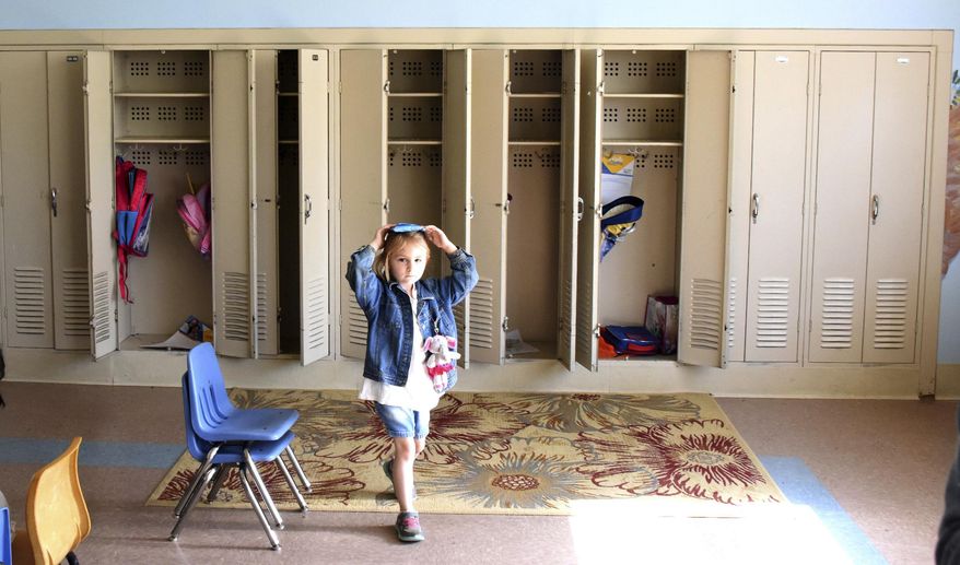 In this Friday, june 2, 2017 photo, Alanna DeLuca , 4, in the "Ready-K" carries items on her head after going to the locker, at St. Ursula School in Hampton Township, Pa. The school is closing and being consolidated. (Darrell Sapp/Pittsburgh Post-Gazette via AP)