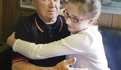 In this May 8, 2017 photo, Rich Ricci hugs his granddaughter, Christie of Lostant, at Rich  Ricci&#x27;s auto repair shop in Utica, Ill. They are part of the La Salle Public Library&#x27;s veterans history project. For the project, Christie plans to record a video interview with her grandfather, who was stationed overseas in 1968- 69 during the Vietnam War. (Scott Anderson/NewsTribune via AP)