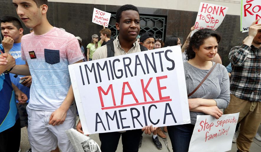 FILE - In this May 16, 2017, file photo, Torianto Johnson, a freshman at Pioneer High School in Ann Arbor, Mich., holds a sign supporting immigrants during a rally outside a federal courthouse in Detroit. For years, immigrants have checked in regularly with federal deportation agents to show they've been following the country's laws even though they have been ordered to leave. Now, in cases spanning from Michigan to California, many of those who have exhausted their legal options are being told their time here is up. (AP Photo/Paul Sancya, File)