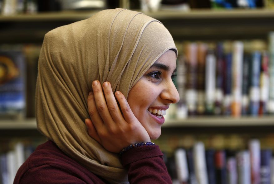 In this June 1, 2017, photo Israa Enan wears a stylish hijab during an interview at Deering High School in Portland, Maine. Enan, who recently graduated, admitted she shied away from going out for high school sports teams because of the embarrassment she would have felt if her stylish scarf fell off during competition. (AP Photo/Robert F. Bukaty)