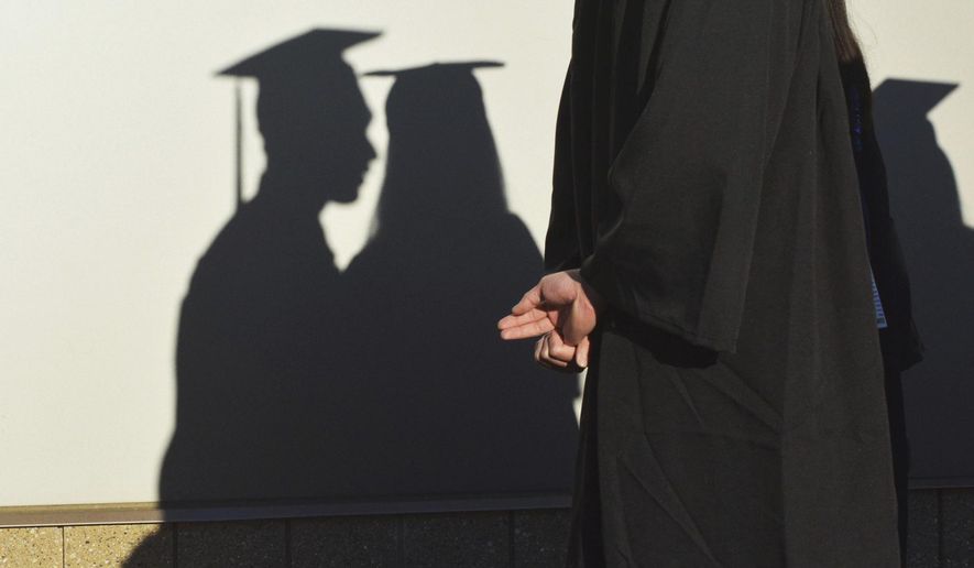 FILE - In this Sunday, May 14, 2017 file photo, university graduates cast shadows on a wall before a commencement in Durham, N.C. In its June 2017 issue, a leading journal of political philosophy took up the Black Lives Matter movement without a single contribution from a black academic, triggering an outcry from African-American scholars. (Bernard Thomas/The Herald-Sun via AP)