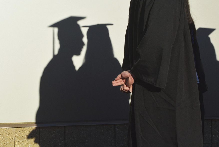 FILE - In this Sunday, May 14, 2017 file photo, university graduates cast shadows on a wall before a commencement in Durham, N.C. In its June 2017 issue, a leading journal of political philosophy took up the Black Lives Matter movement without a single contribution from a black academic, triggering an outcry from African-American scholars. (Bernard Thomas/The Herald-Sun via AP)