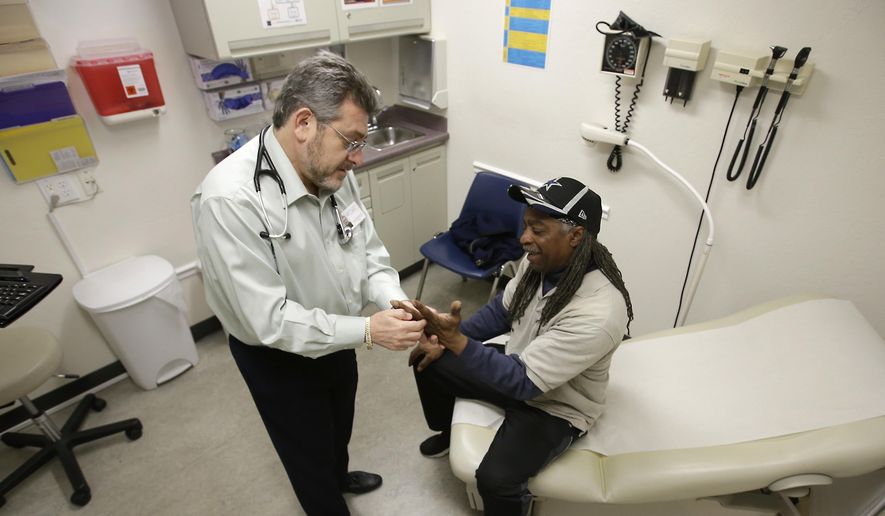  In this Feb. 18, 2016 file photo, Doctor Leonid Basovich, left, examines Medi-Cal patient Michael Epps, at the WellSpace Clinic in Sacramento, Calif. (AP Photo/Rich Pedroncelli, File) **FILE**