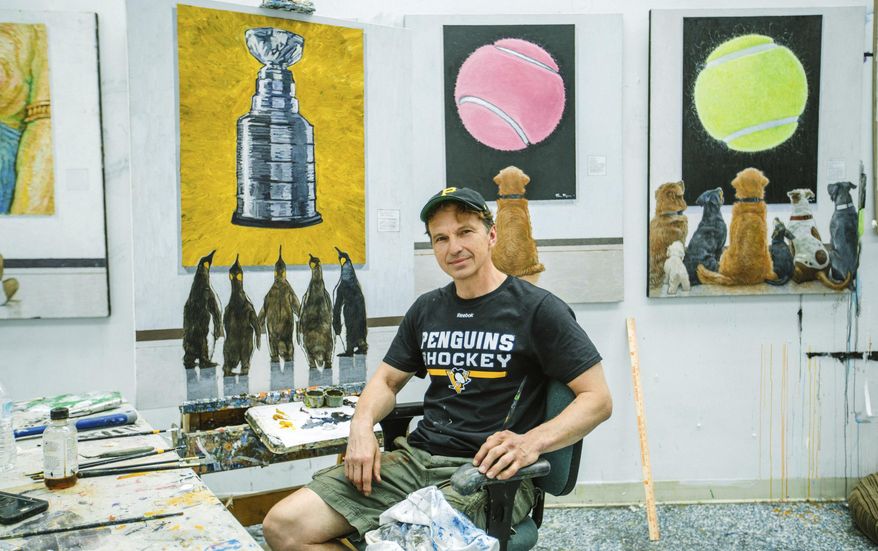 ADVANCE FOR USE SATURDAY, JUNE 10 - In this Friday, June 2, 2017 photo, Tom Mosser sits in front of his unfinished painting, "Penguins at the Museum" at his studio in Etna, Pa. Anyone who went to a Pirates game from 1988-96 has seen Mosser, though he was usually obscured by green feathers and a big yellow beak. His new project combines his love of Pittsburgh sports and lifelong penchant for artistry: a painting "Penguins at the Museum" depicting five king penguins gazing at a painting of the Stanley Cup. (Andrew Rush/Pittsburgh Post-Gazette via AP)