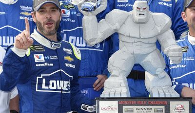 Jimmie Johnson, left, poses with the trophy in Victory Lane after he won a NASCAR Cup series auto race, Sunday, June 4, 2017, at Dover International Speedway in Dover, Del. (AP Photo/Nick Wass)