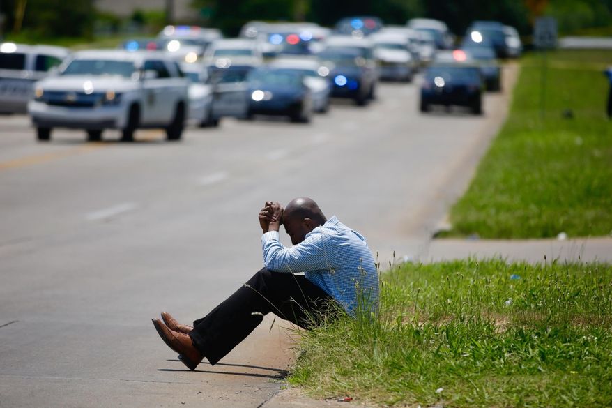 Police Chaplain Andru Morgan prays at the scene of an officer involved shooting, Friday, June 9, 2017 in Tulsa, Okla. Law officers in Tulsa fatally shot a man while trying to pick him up for a mental health issue, triggering a street protest and a corresponding show of force by police in riot gear. (Mike Simons/Tulsa World via AP)
