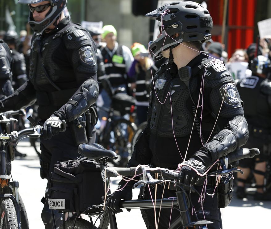 A Seattle Police officer who was sprayed with silly string stands on a police line during a counter-protest to anti-Islamic law rally Saturday, June 10, 2017, in Seattle.  Rallies against Islamic law have drawn larger counter-rallies in some U.S. cities. Hundreds of counter-protesters marched through Seattle on Saturday to confront a few dozen people claiming Shariah is incompatible with Western freedoms. (AP Photo/Ted S. Warren)