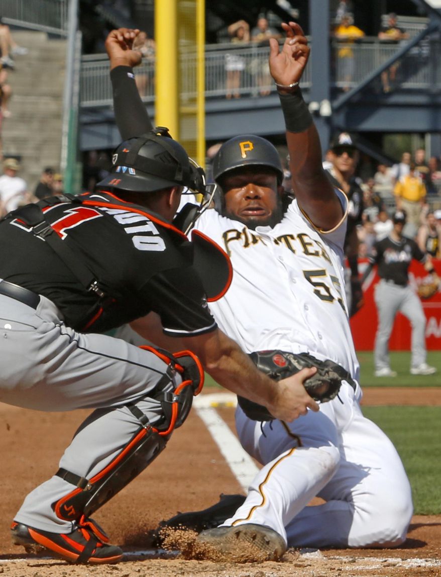 Miami Marlins catcher J.T. Realmuto, left, puts the tag on Pittsburgh Pirates' Josh Bell, who was trying to score on a double by Andrew McCutchen during the third inning of a baseball game in Pittsburgh, Saturday, June 10, 2017. (AP Photo/Gene J. Puskar)