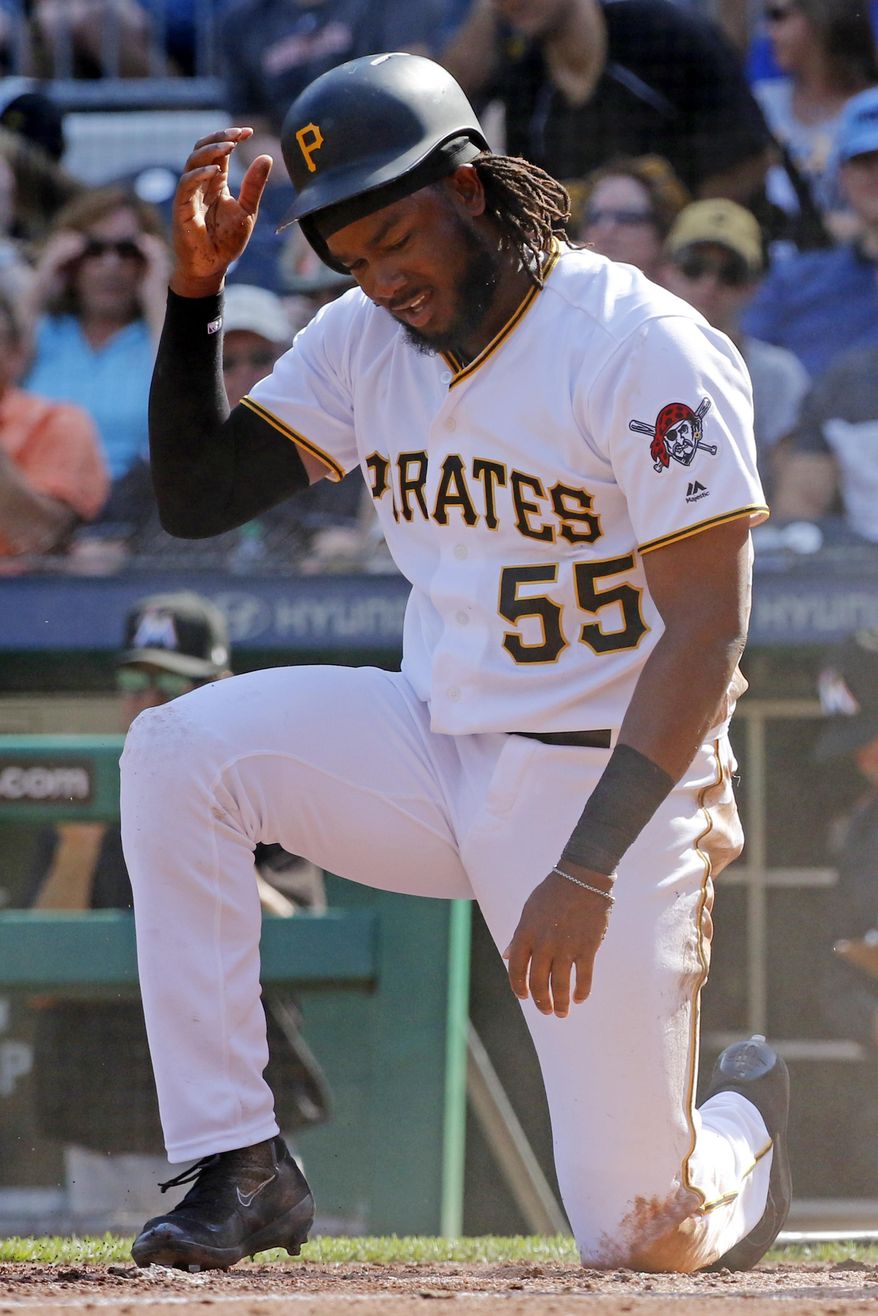 Pittsburgh Pirates' Josh Bell (55) gets up after being tagged out by Miami Marlins catcher J.T. Realmuto after trying to score on a double by Pirates' Andrew McCutchen in the third inning of a baseball game in Pittsburgh, Saturday, June 10, 2017. (AP Photo/Gene J. Puskar)