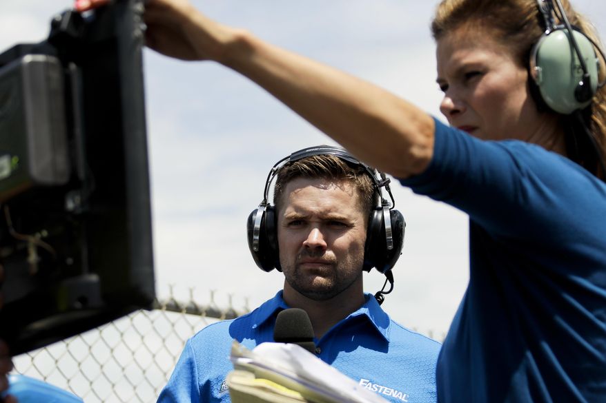 Driver Ricky Stenhouse Jr., left, and broadcast pit reporter Jamie Little look over a monitor during the NASCAR xfinity Series auto race, Saturday, June 10, 2017, in Long Pond, Pa. (AP Photo/Matt Slocum)