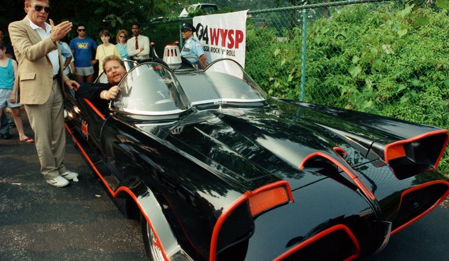 FILE - In this June 27, 1989 file photo, Adam West, left, stands beside the old Batmobile driven by owner Scott Chinery in Philadelphia. On Saturday, June 10, 2017, his family said the actor, who portrayed Batman in a 1960s TV series, has died at age 88. (AP Photo/Cristy Rickard, File)