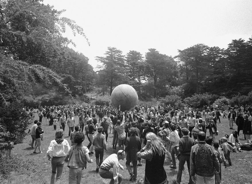 ADVANCE FOR USE TUESDAY, JUNE 13, 2017 AND THEREAFTER-FILE - In this June 21, 1967 file photo, people keep a large ball, painted to represent a world globe, in the air during a gathering at Golden Gate Park in San Francisco, to celebrate the summer solstice on June 21, day one of "Summer of Love." City officials have rejected a permit for a planned free concert intended to mark the 50th anniversary of the famed Summer of Love in Golden Gate Park that had been planned for June 2017. (AP Photo/File)