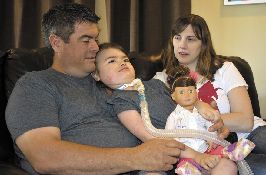FOR RELEASE SUNDAY, JUNE 11, 2017, AT 12:01 A.M. CDT.- J.D. Myers, of Hardy, left, holds his daughter, Ava Myers, as they sit on a couch together at their home recently. Jenni Myers is shown to the right. Ava Myers, who wants to be a doctor when she grows up, his holding a doll named after her. Ava Myers brother, Jack Myers, 11, is not pictured. He was in school at the time of the photo. (Chad Thomas /The Messenger via AP)