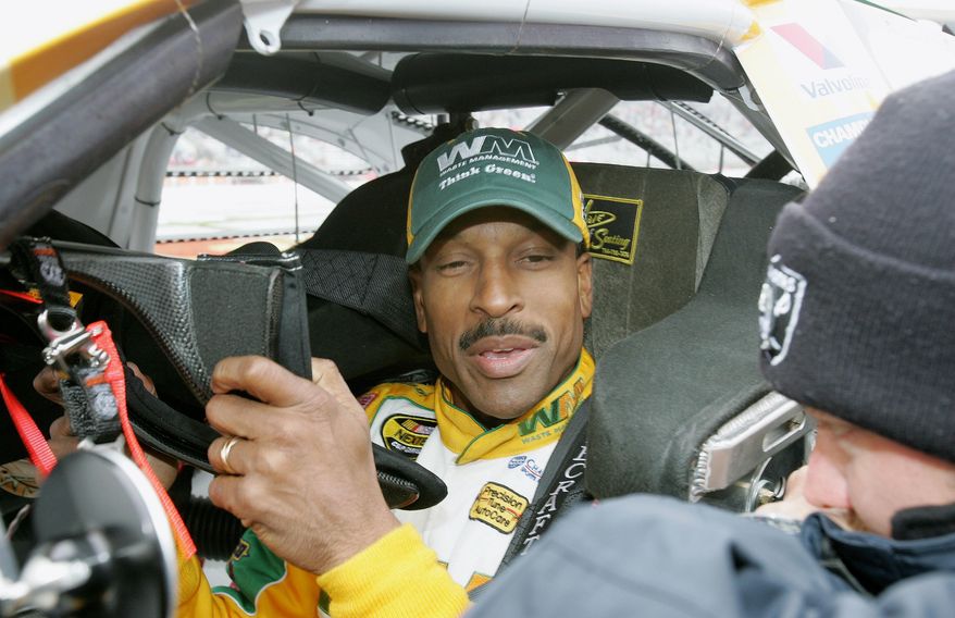 FILE - In the March 20, 2006, file photo, NASCAR driver Bill Lester puts on his head and neck restraint in his car as he gets ready for a rain-delayed start of the NASCAR Golden Corral 500 auto race at Atlanta Motor Speedway, in Hampton, Ga. On Sunday, June 11, 2017, Darrell Wallace Jr. became just the eighth black driver to race in NASCAR&#x27;s top Cup series when he started at Pocono Raceway.  Lester was rooting for Wallace on Sunday. Lester made two starts in 2006 and was the last black driver to make a Cup start. Lester met Wallace at a Truck race in Kansas a few years ago and had followed his progression through NASCAR. (AP Photo/Ric Feld, File)