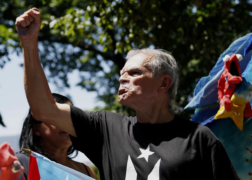 Oscar Lopez Rivera participates in the Puerto Rican Day Parade in New York, Sunday, June 11, 2017. Lopez Rivera was cheered and booed as he stood proudly on a float when the parade stepped off Sunday. (AP Photo/Seth Wenig)
