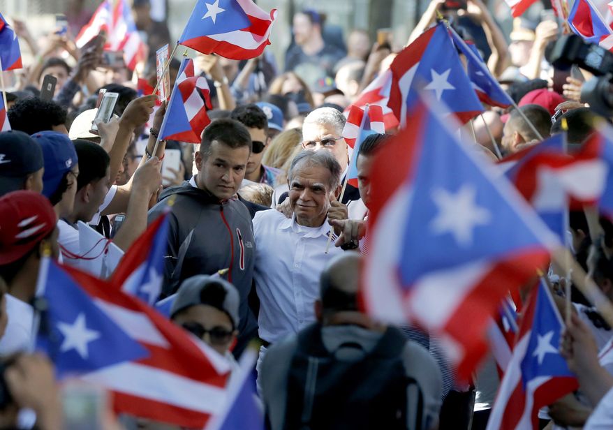 FILE- In this May 18, 2017 file photo, Puerto Rican nationalist Oscar Lopez Rivera, center, arrives for a gathering in his honor in Chicago's Humboldt Park neighborhood. New York City's annual Puerto Rican Day parade will take place under a cloud of controversy this year because of a decision by organizers to honor OscarLopez Rivera, who spent decades in prison because of his involvement with the terrorist group FALN. (AP Photo/Charles Rex Arbogast, File)