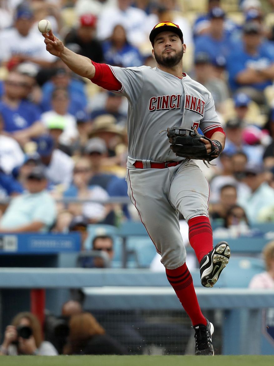 Cincinnati Reds third baseman Eugenio Suarez throws to first base to get out Los Angeles Dodgers' Enrique Hernandez during the sixth inning of a baseball game, Sunday, June 11, 2017, in Los Angeles. (AP Photo/Ryan Kang)