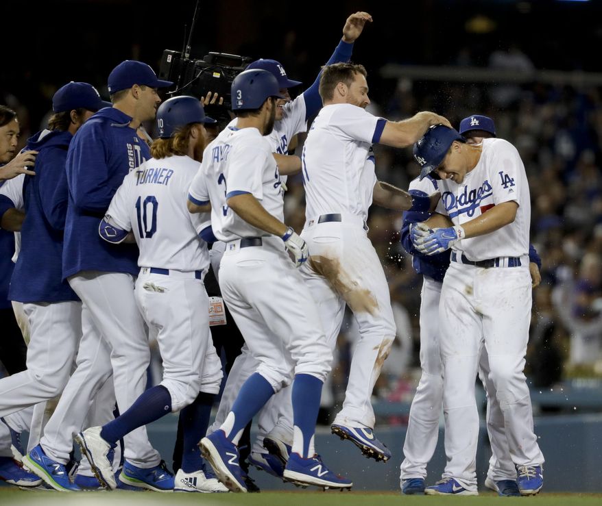 Los Angeles Dodgers greet Corey Seager, right, after his walk-off double against the Cincinnati Reds during a baseball game in Los Angeles, Saturday, June 10, 2017. The Dodgers won 5-4. (AP Photo/Chris Carlson)
