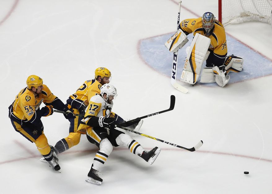 Pittsburgh Penguins&#x27; Bryan Rust (17) battles for the puck against Nashville Predators&#x27;s Cody McLeod (55) and Matt Irwin (52) as Nashville Predators goalie Pekka Rinne (35), of Finland, guards the goal during the second period of Game 6 of the NHL hockey Stanley Cup Final, Sunday, June 11, 2017, in Nashville, Tenn. (AP Photo/Jeff Roberson)