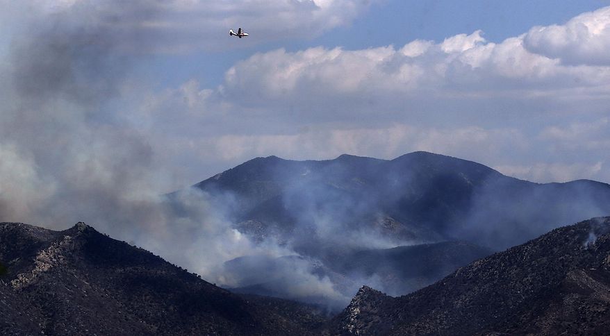 This June 9, 2017, photo shows an air tanker making its approach over the Lizard Fire as the wildfire burns in the Dragoon Mountains as seen from Texas Canyon and Interstate 10 in Southeastern Ariz. (Mike Christy/Arizona Daily Star via AP)